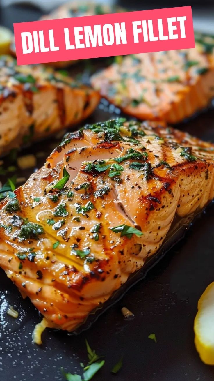 Close-up of grilled salmon with lemon and fresh herbs on a plate.
