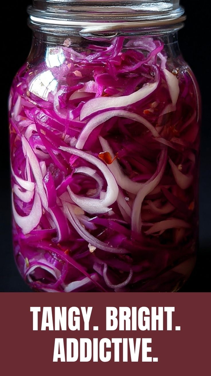 Vibrant pickled red onions in a clear glass jar.