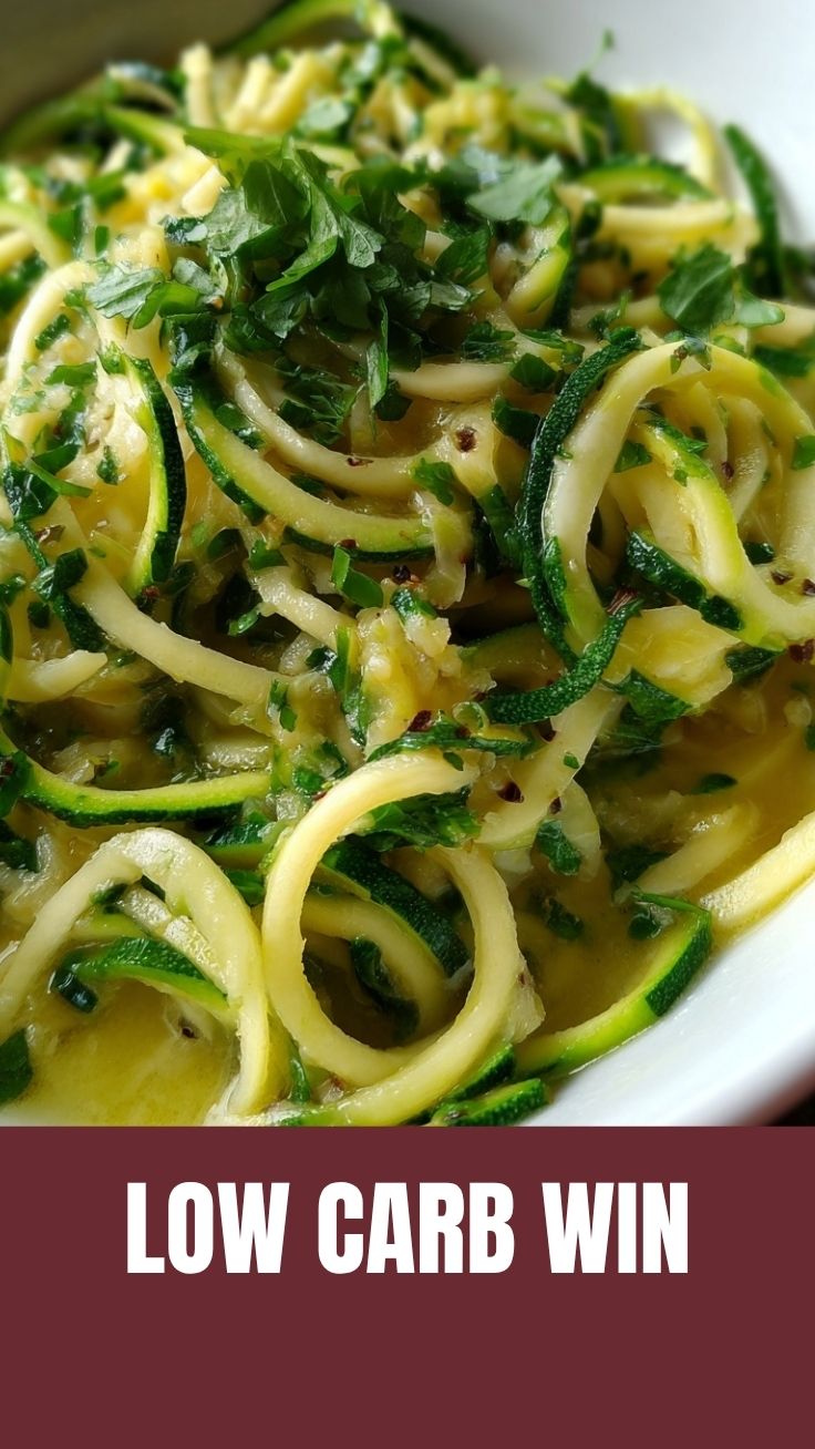 A fresh pile of vibrant green zucchini noodles on a cutting board, ready for cooking.